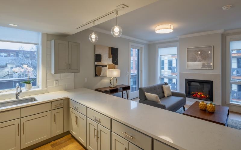 a kitchen with a view of a living room and fireplace
